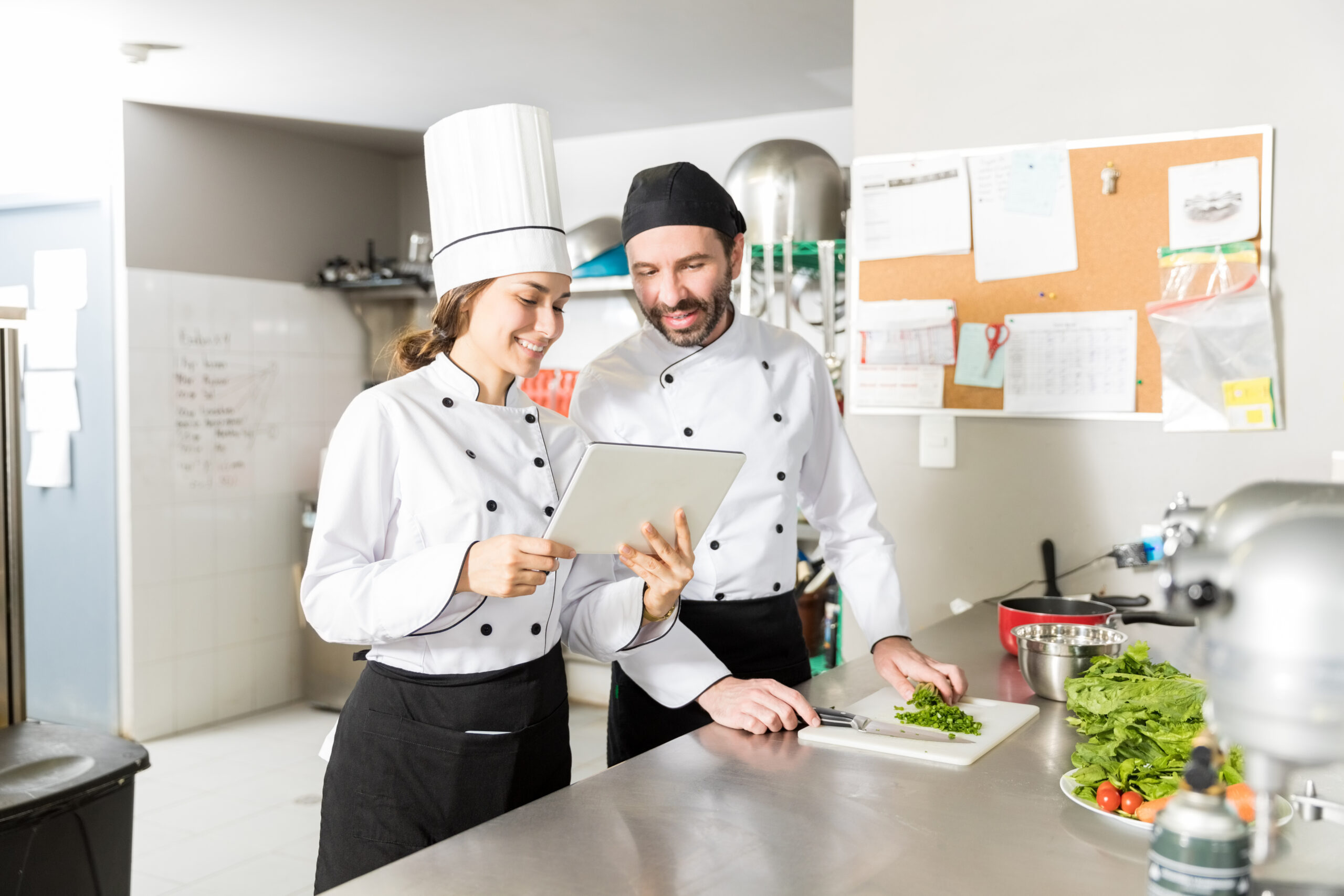 Hispanic Chefs Using Digital Tablet In Kitchen