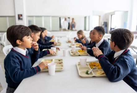 Group of Latin American children eating their lunch at the schools cafeteria